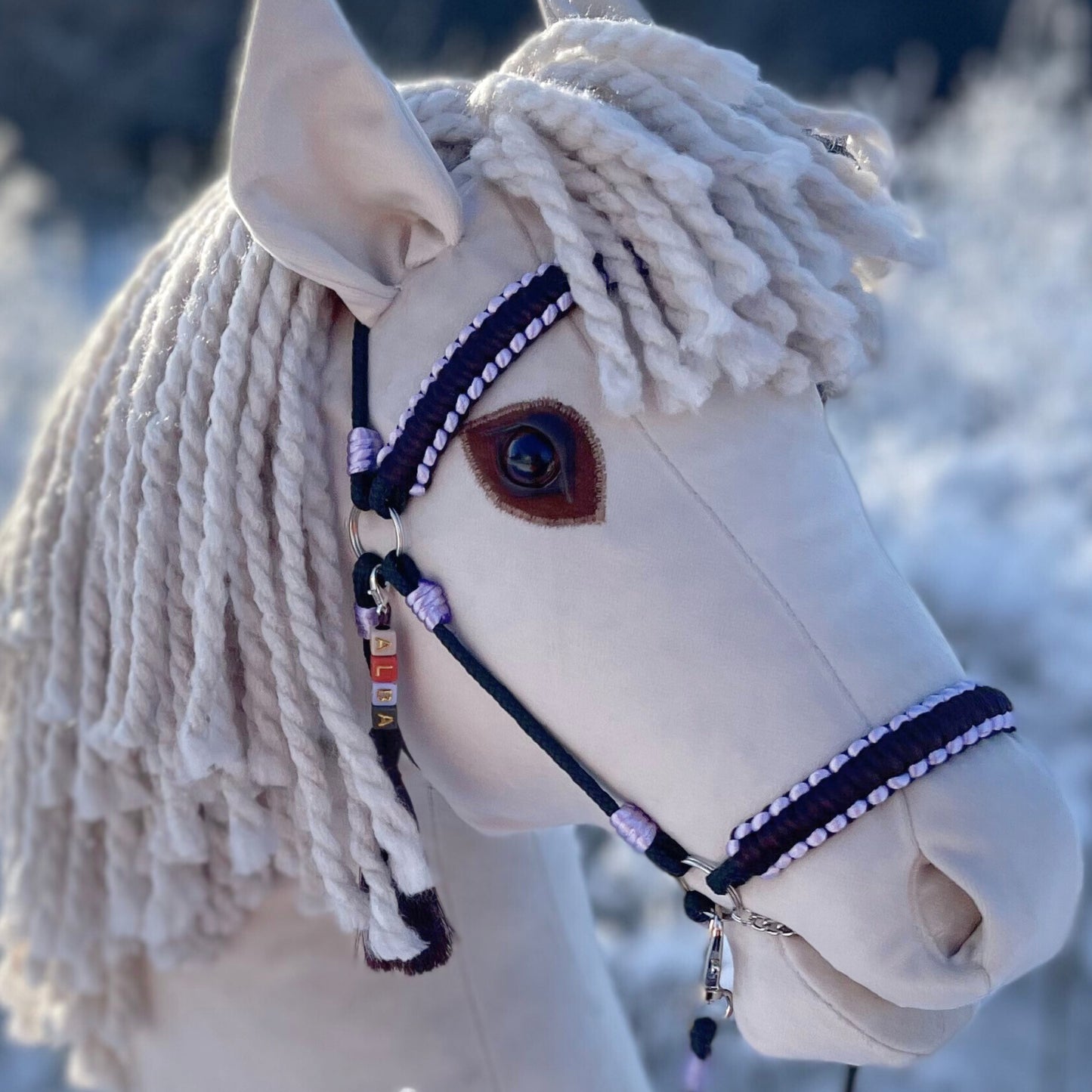 Ivory hobby horse stick horse outdoors, winter nature background