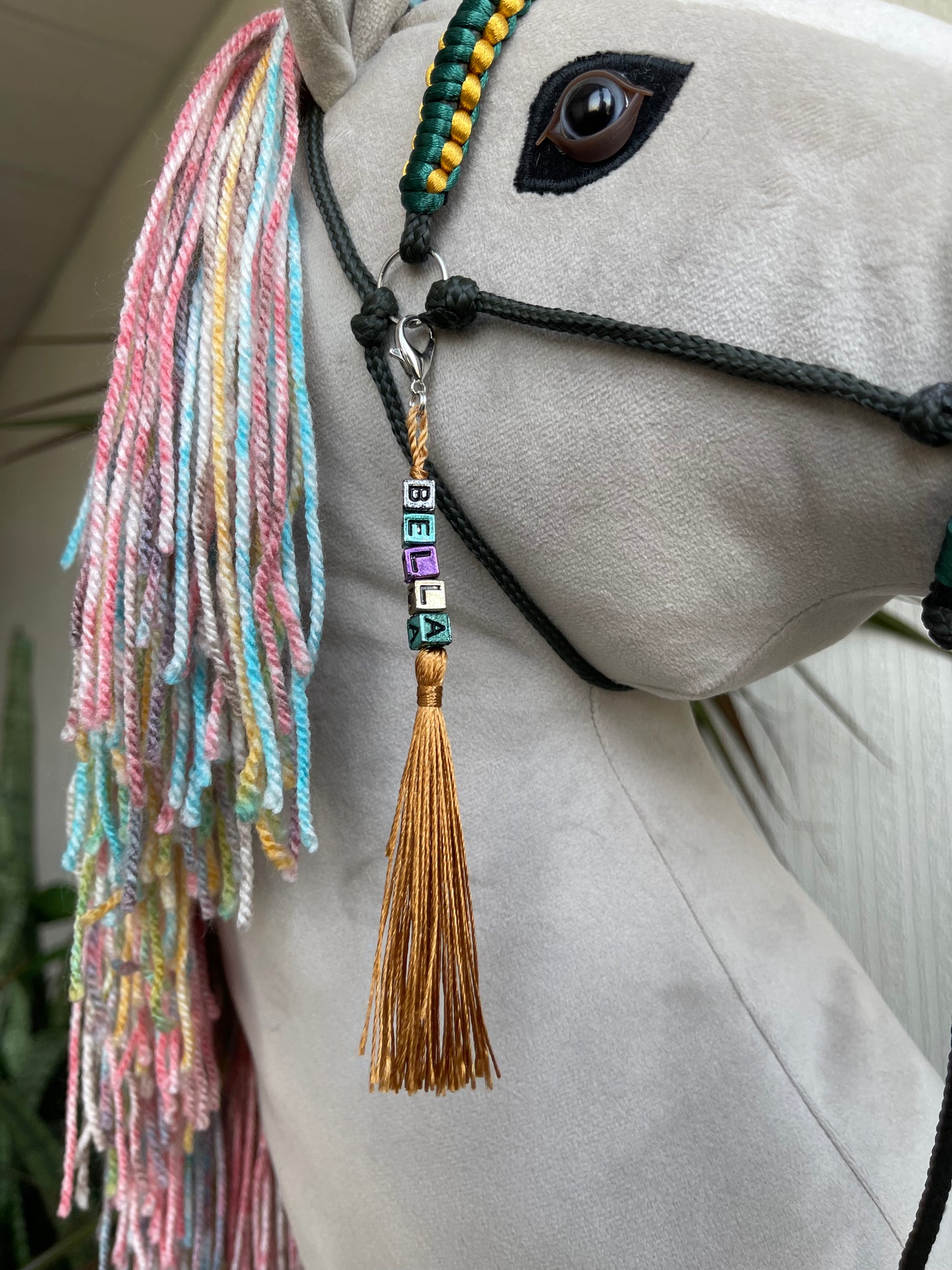 Light gray hobby horse with rainbow mane and green bridle, handmade stick horse for children role play and hobby horse riding.