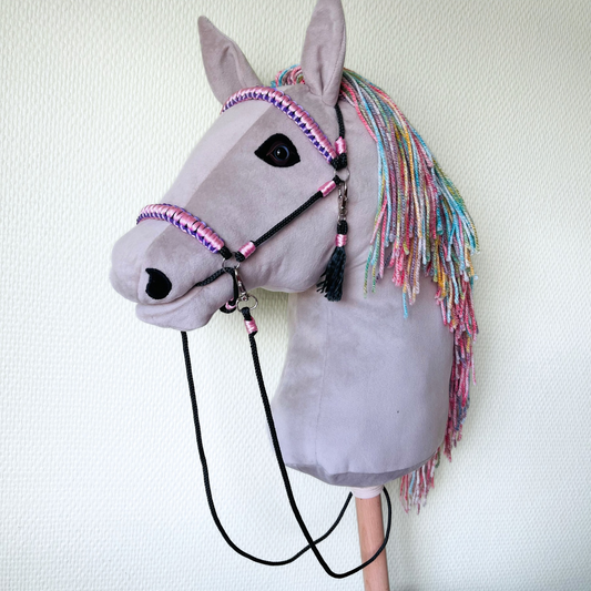 Light gray handmade hobby horse with rainbow mane and pink bridle, stick horse toy for kids and hobby horsing.