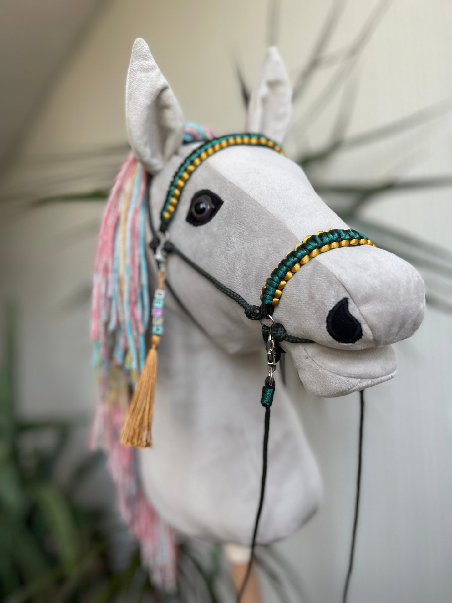 Light gray hobby horse with rainbow mane and green bridle, handmade stick horse for children role play and hobby horse riding.