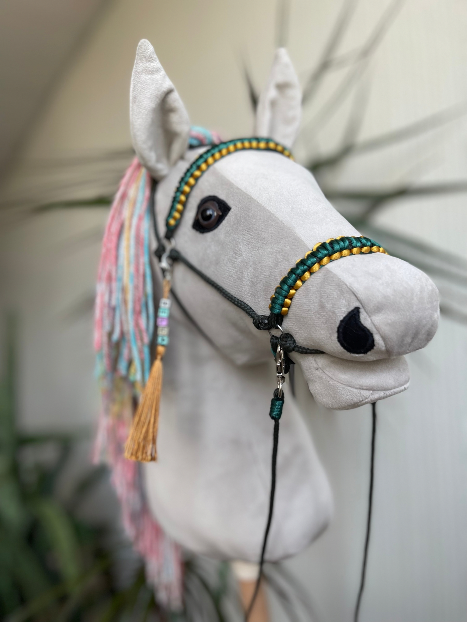 Light gray hobby horse with rainbow mane and green bridle, handmade stick horse for children role play and hobby horse riding.