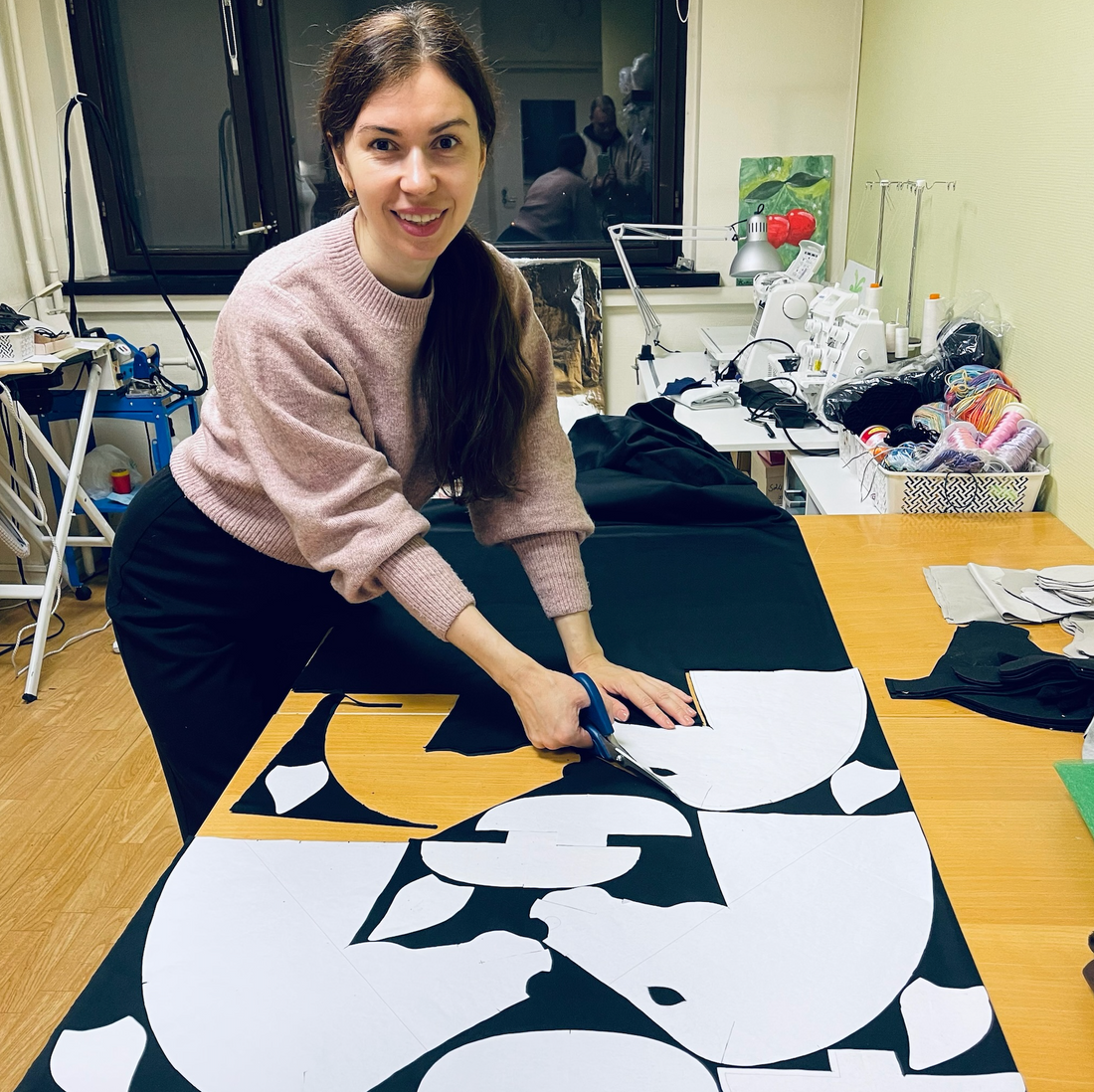 Cutting high-quality fabric pieces for a handmade black hobby horse in the workshop