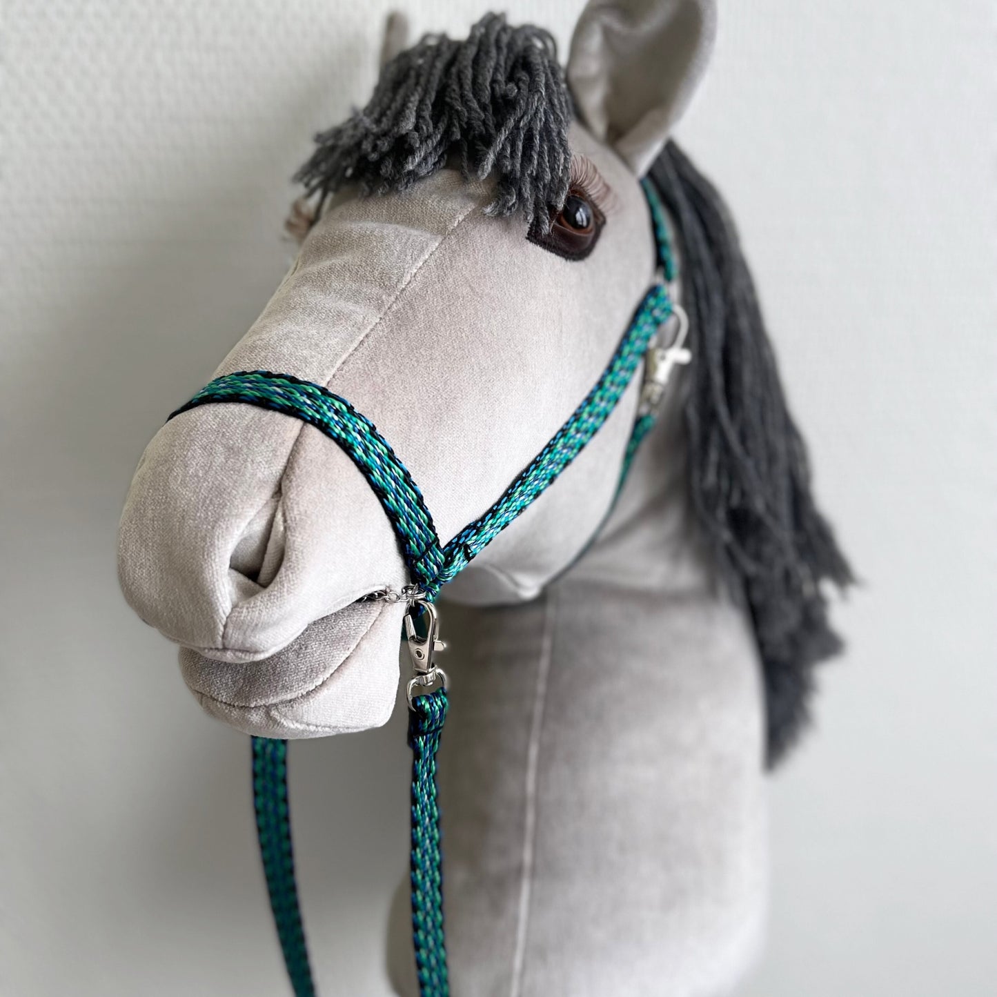 Handmade gray hobby horse, side view on neutral studio background