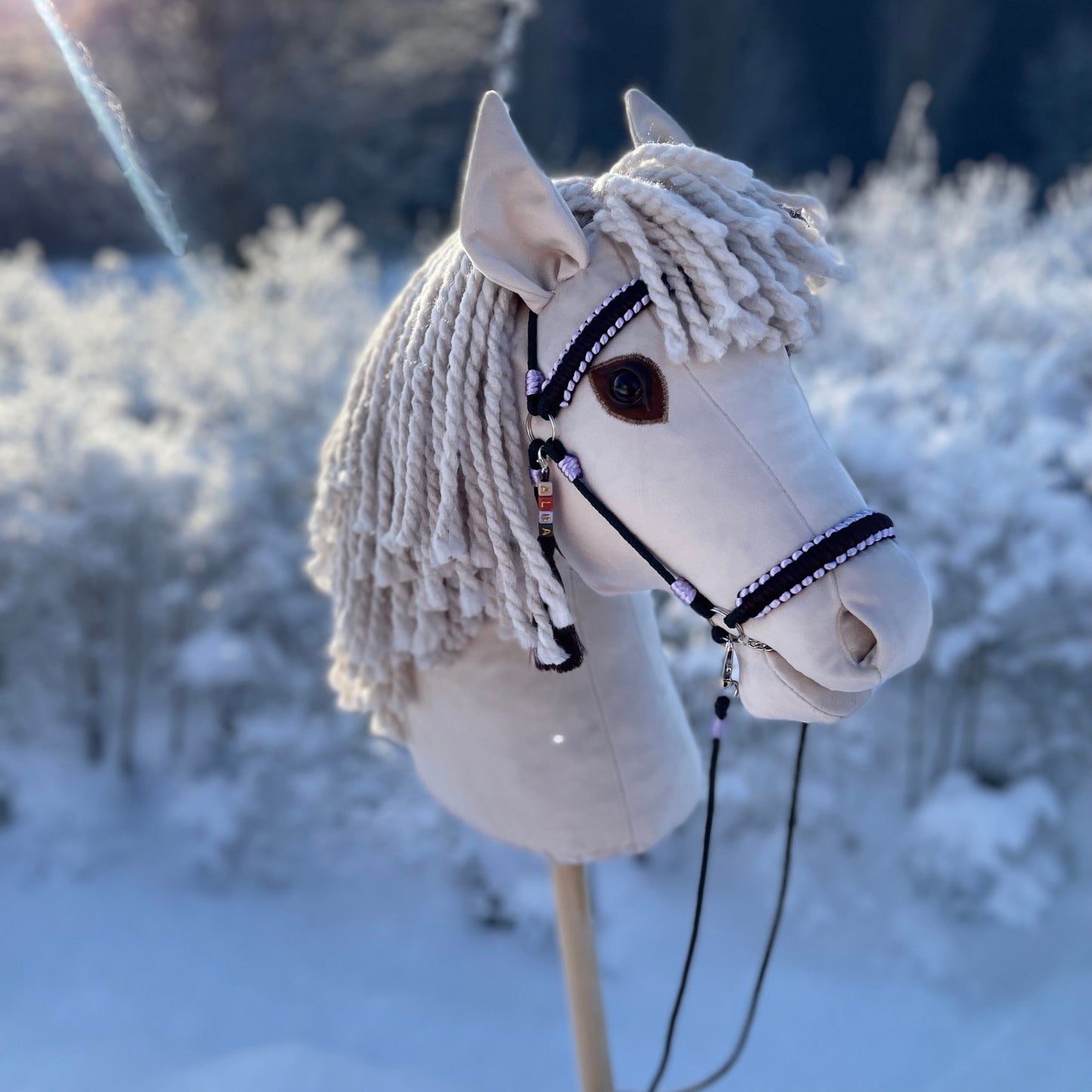 Close-up of ivory handmade hobby horse with thick yarn dreadlock-style mane