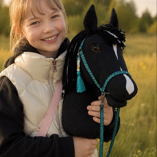 Smiling girl holding black handmade hobby horse Eclipse outdoors – realistic stick horse for kids and hobby horsing